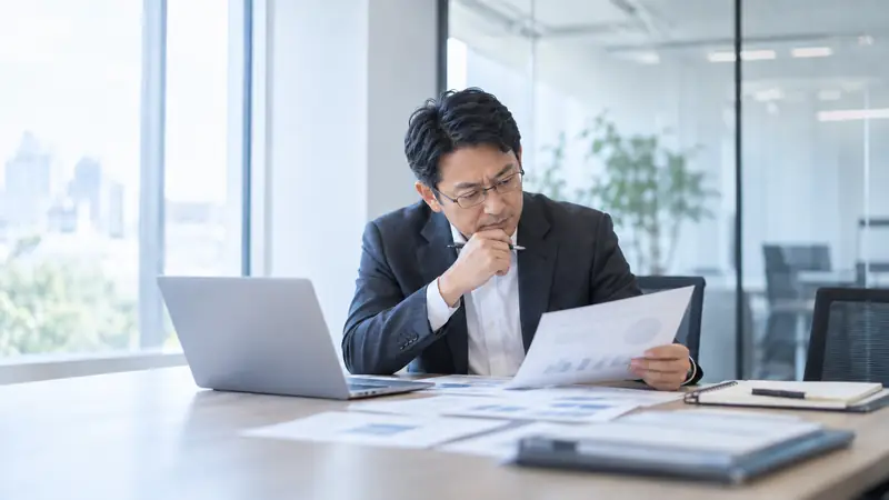経営企画の担当者が、グラフの資料を見ながら検討する様子